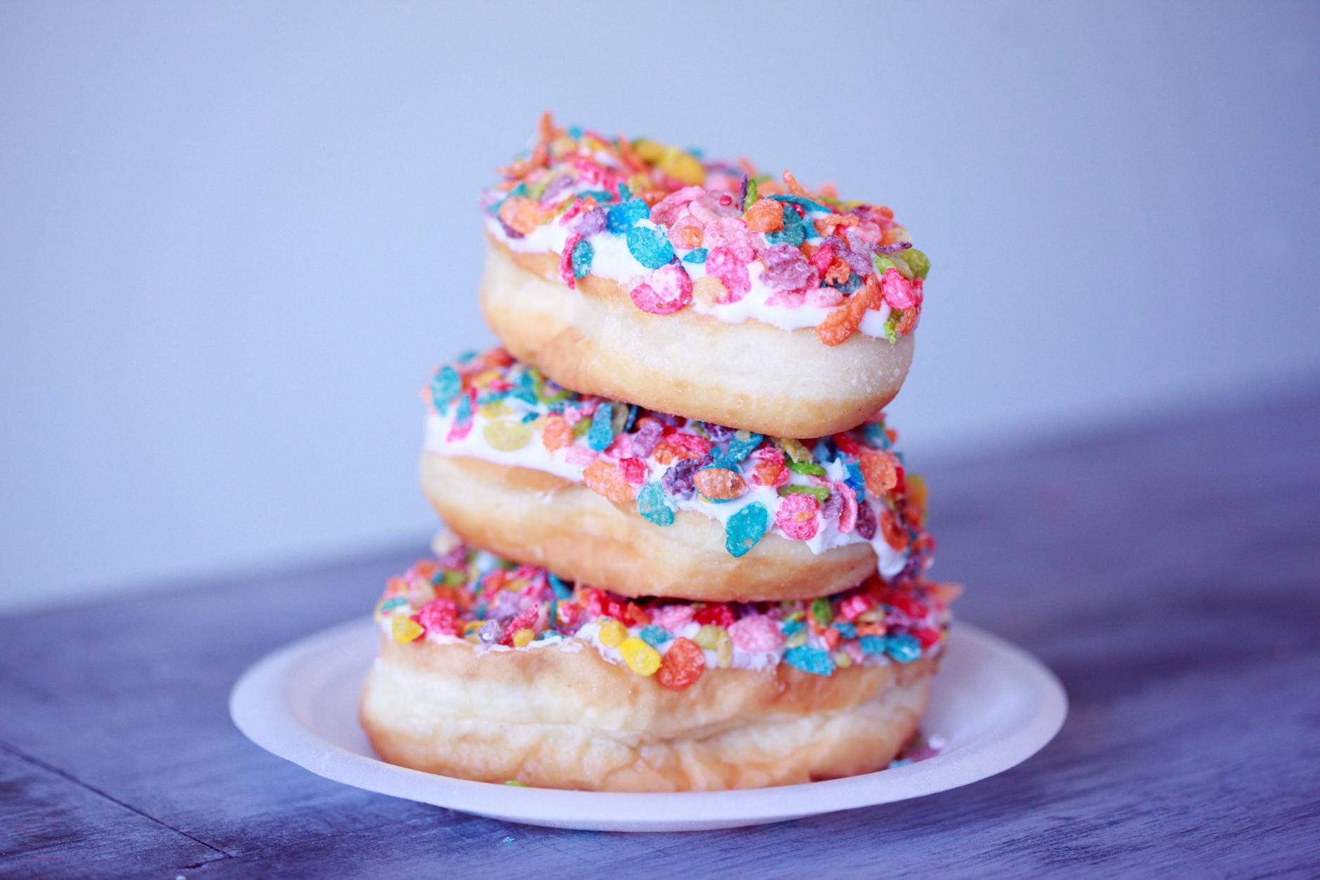 une pile de donuts colorés symbolisant le sucre et les aliments transformés