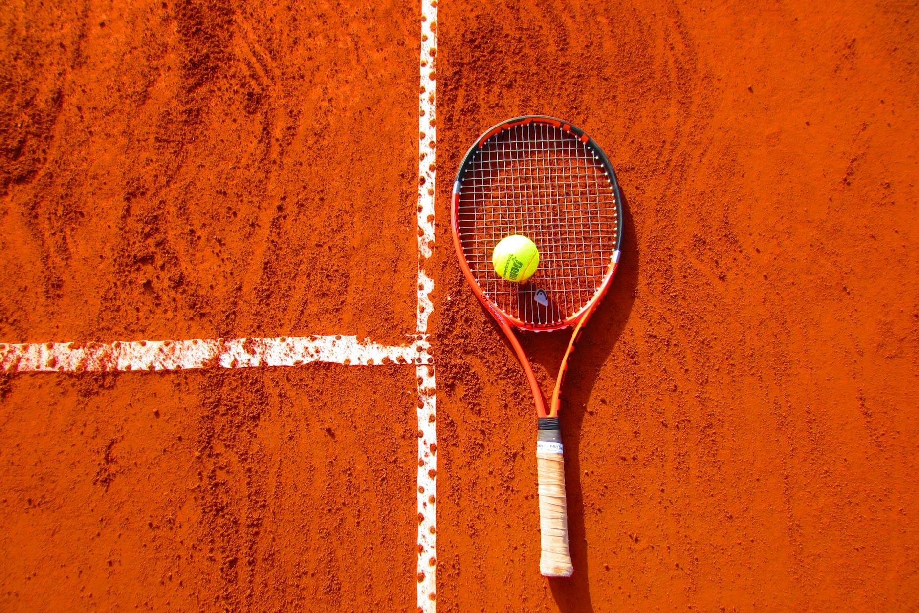 Une raquette de tennis et une balle de tennis. Symbolisant l'activité physique régulière bénéfique pour réguler le niveau de dopamine.